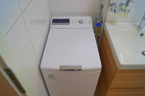 a small bathroom with a sink and a white refrigerator at Zentrum Speyer Premium-Apartment in Speyer