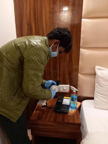a man in a hotel room putting something on a table at Olivia Hotels At Delhi Airport in New Delhi