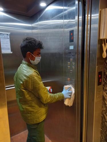 a man wearing a face mask in an elevator at Olivia Hotels At Delhi Airport in New Delhi
