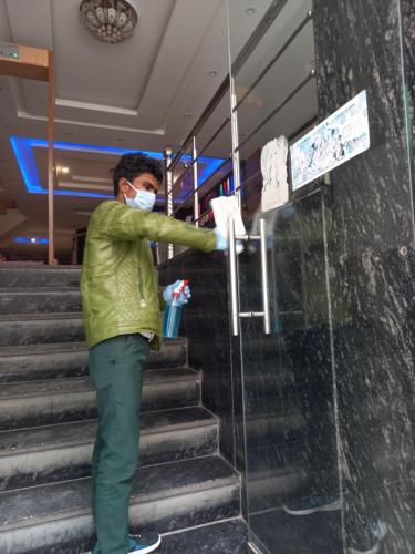 a man is standing on stairs with a mask on at Olivia Hotels At Delhi Airport in New Delhi
