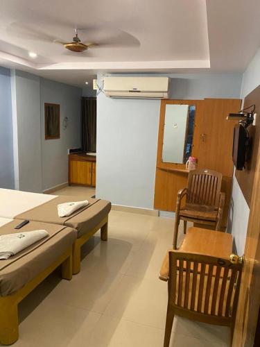 a room with two beds and a white wall at KVP RESIDENCY in Tirupati