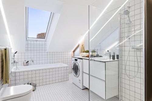 a white bathroom with a washing machine in it at BJØRVIKA APARTMENTS - Solli in Oslo