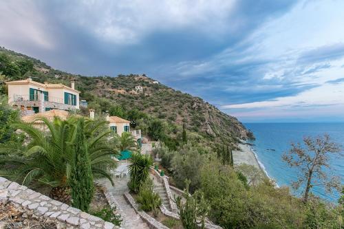 a house on a hill next to the ocean at Kissakas Villas in Leonidion