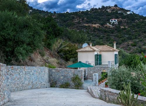 a house on a hill with a stone wall at Kissakas Villas in Leonidion