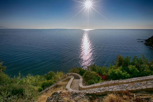 a view of the ocean with the sun in the sky at Kissakas Villas in Leonidion