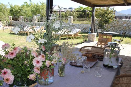 a table with vases of flowers on it at The Farmstead in Franschhoek