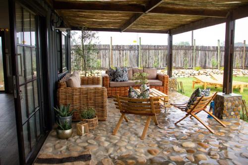 a screened in porch with a couch and chairs at The Farmstead in Franschhoek