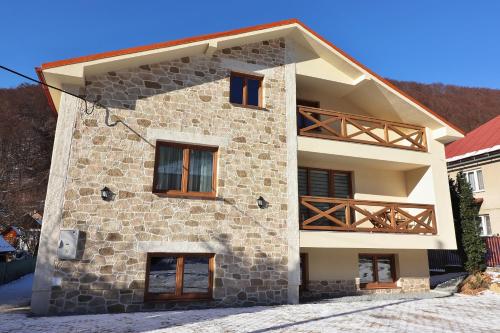 a house with a stone facade with a balcony at Chata Matzo in Mýto pod Ďumbierom