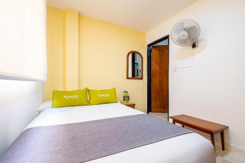 a bedroom with a white bed and a fan at Ayenda 1502 Principe in Bucaramanga