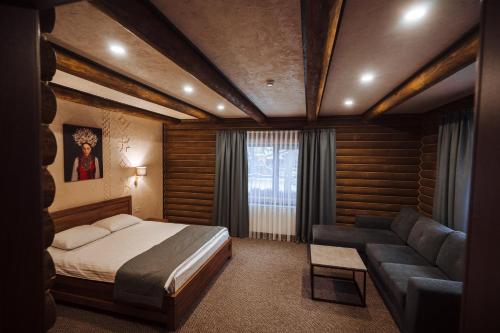 a bedroom with a bed and a couch at Turiyske Podvir'ya in Blazhennik