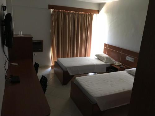 a hotel room with two beds and a television at MIX APART Hotel in Brasília