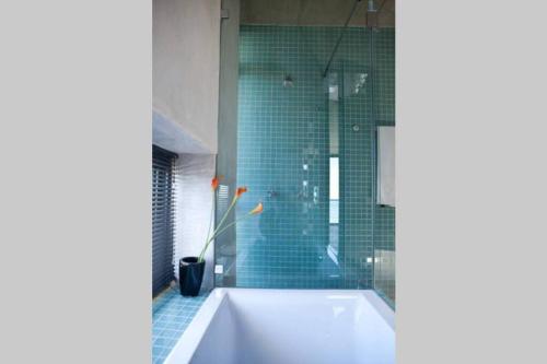 a bathroom with a tub and a glass shower at VAME Beachfront in Yzerfontein