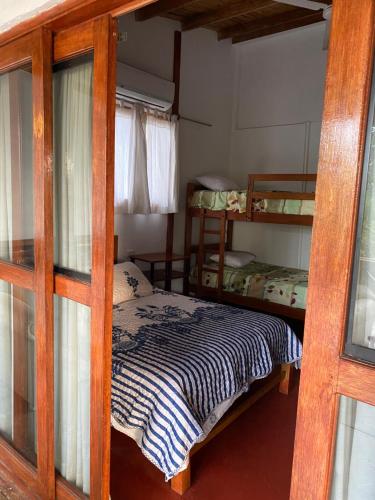 a bedroom with a bed and two bunk beds at Villa Mistika in Zorritos