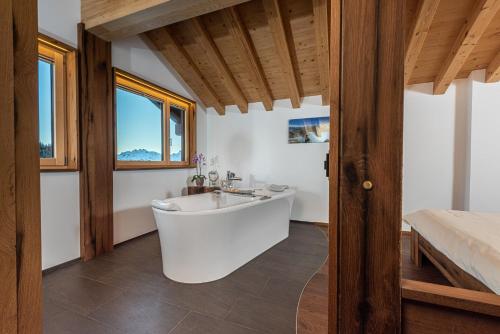 a bathroom with a tub and a bed at Hotel Slalom in Bettmeralp