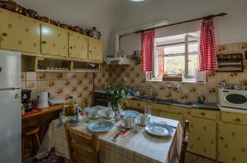 a kitchen with a table with chairs and a refrigerator at Irini and Petros House in Leonidio