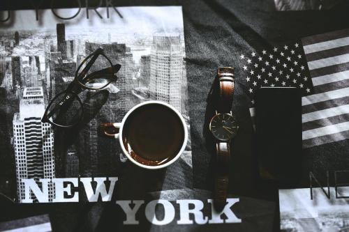 a new york poster with a cup of coffee and a watch at Hyatt Place New York Chelsea in New York