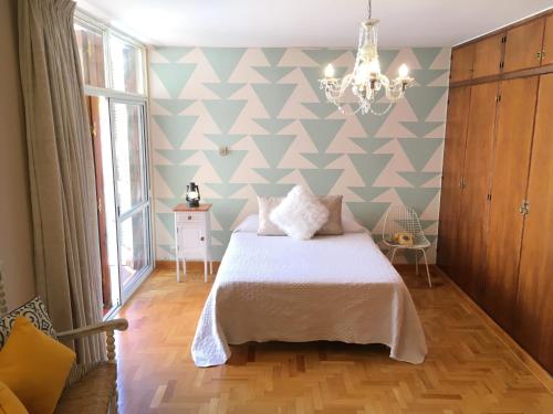 1 dormitorio con cama y pared geométrica en La Casa del Parque B&B en Mendoza