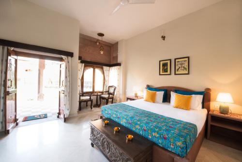 a bedroom with a large bed and a table at Kot Dunara - A 16th Century Castle near Jodhpur in Jodhpur