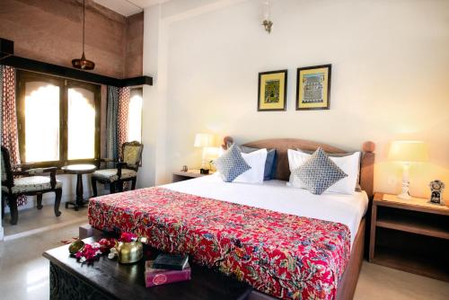 ジョードプルにあるKot Dunara Jodhpurのベッドルーム1室(赤毛布付きの大型ベッド1台付)