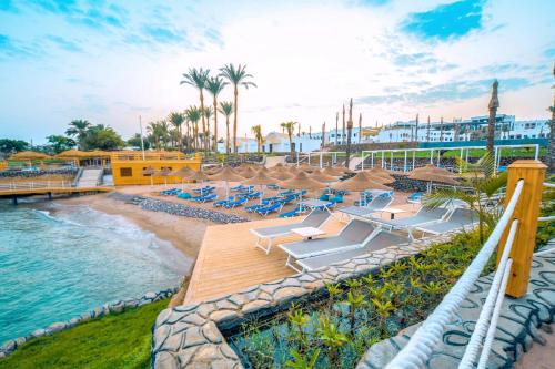 um resort com uma piscina e cadeiras e uma praia em Sunrise Diamond Beach Resort -Grand Select em Sharm el Sheikh