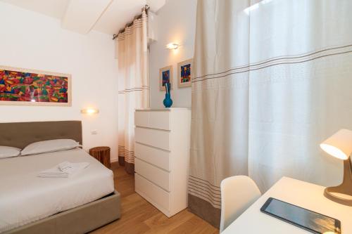 a bedroom with a bed and a table with a desk at ALTIDO Cosy 1bed flat in Fiera, Milan in Milan