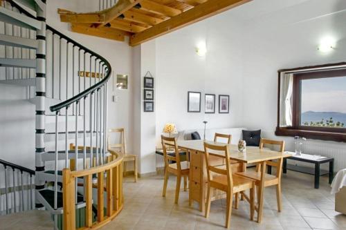 jadalnia ze stołem i spiralnymi schodami w obiekcie Katevi Luxury Seafront Villa w mieście Ierissós