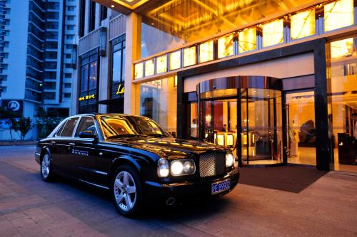 a black car parked in front of a building at Wealthy All Suite Hotel Suzhou in Suzhou