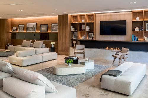 a living room with white furniture and a tv at Amarilia Hotel in Athens