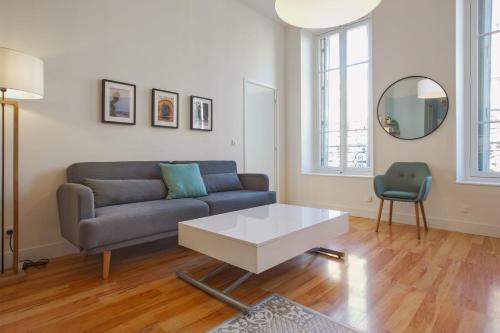 un salon avec un canapé et une table dans l'établissement Appartement Cathala - Welkeys, à Marseille