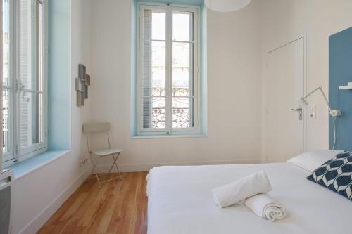 une chambre blanche avec un lit et une fenêtre dans l'établissement Appartement Cathala - Welkeys, à Marseille