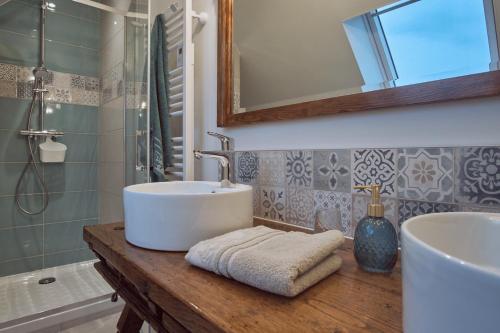 a bathroom with a sink and a mirror and a tub at A l'Ombre des Pommiers in Ergué-Gabéric