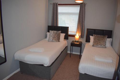 Un pat sau paturi într-o cameră la 3 Bedroom-Kelpies Serviced Apartments Burns