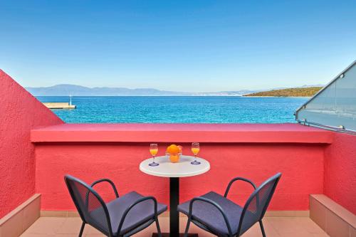 a table and chairs on a balcony with a view of the water at Veya Maradiso Hotel by Aminess in Njivice