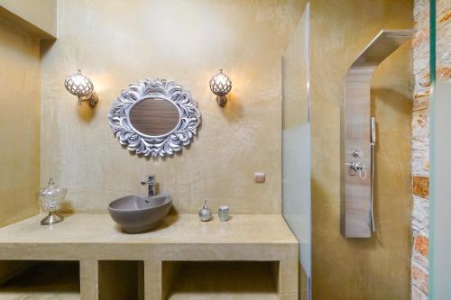 a bathroom with a sink and a mirror on the wall at Kastro Stone House in Skala Potamias