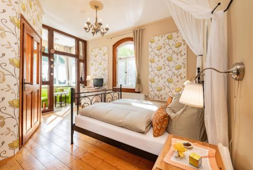 - une chambre avec un lit et une table dans l'établissement Hotel Villa Rossek, à Bad Liebenstein