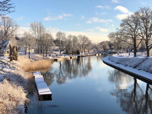 a river in a park with snow on the ground at Pensionat Kanalvillan in Väddö