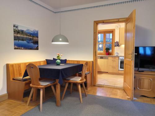 cocina y comedor con mesa y sillas en Ferienhaus Erika, en Garmisch-Partenkirchen
