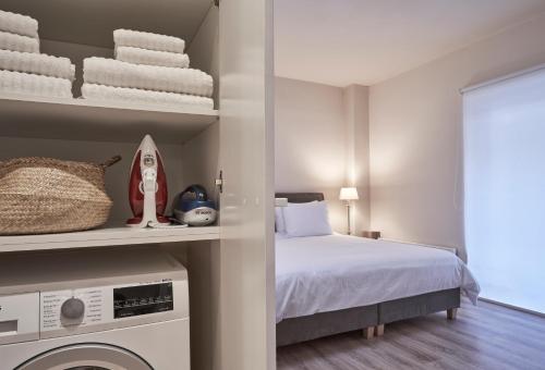 een slaapkamer met een bed en een wasmachine bij Charitos IΧ, Chic n modern 2BD Apt in Athene