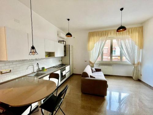 uma cozinha e sala de estar com uma mesa e um sofá em INTERNO DIECI em Roma
