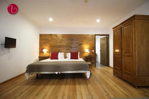a bedroom with a large bed and a wooden wall at GuestHouse Vila Lusitania in Funchal