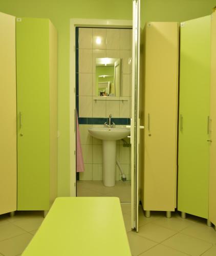 a bathroom with green doors and a sink at Karavella in Mykolaiv
