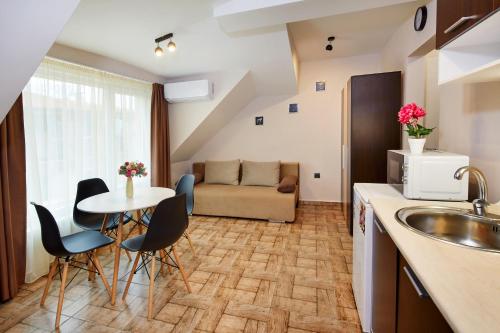 a kitchen and living room with a table and chairs at Feniks Apartments in Nesebar