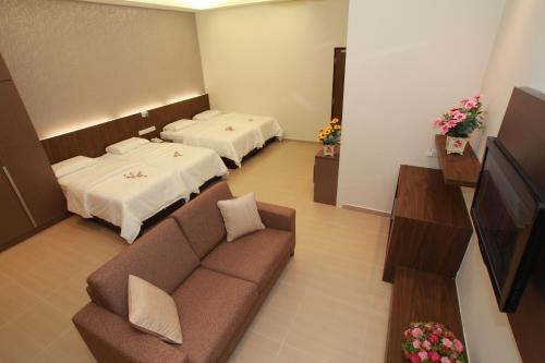 Habitación de hotel con 2 camas y sofá en Tai Ichi Hotel Kuala Lumpur, en Kuala Lumpur