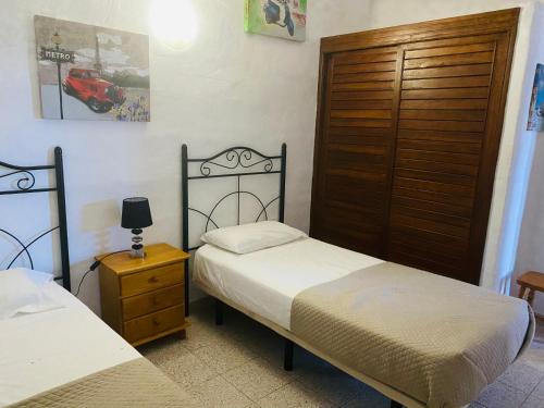 Un dormitorio con dos camas y una puerta de madera. en Casas Rita, en La Frontera