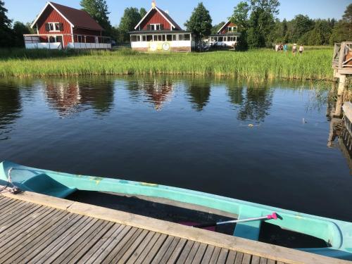 a boat sitting on the water next to a dock at Pensionat Kanalvillan in Väddö