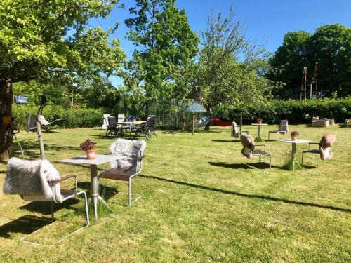 a group of chairs and tables in the grass at Pensionat Kanalvillan in Väddö