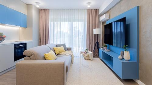 sala de estar con sofá y TV en Il Lago - Azur - Cozy Luxurious Smart Home By The Lake, en Voluntari