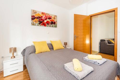 1 dormitorio con 1 cama con 2 almohadas amarillas en Apartman Angie in the centre of Metkovic, en Metković