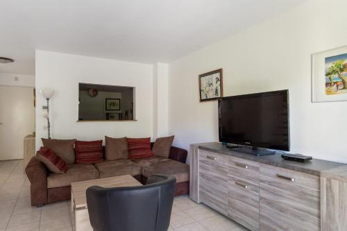 Una sala de estar con un sofá y un televisor de pantalla plana. en Maison La Fontonne - Welkeys, en Antibes