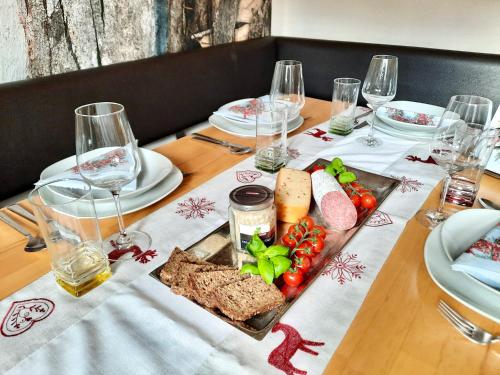 a table with a plate of food and wine glasses at Kitzbühel Apartments Haus Brugger in Kitzbühel